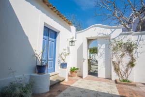 a white house with a door and potted plants at Tenuta Del Poggio Antico in Ischia
