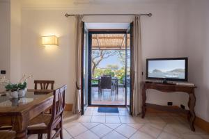 a dining room with a dining table and a sliding glass door at Tenuta Del Poggio Antico in Ischia