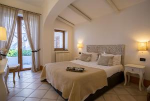 a bedroom with a large bed with a table and a window at Tenuta Del Poggio Antico in Ischia +37 photos