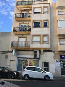 a white car parked in front of a building at Apartamento Puerto-Playa Gandia in Gandía