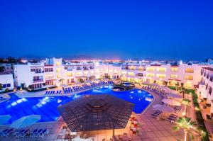 Old Vic Sharm Resort في شرم الشيخ: إطلالة علوية على مسبح في مدينة في الليل