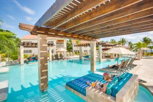 サン・ペドロにあるBelizean Shores Resortの- リゾートのプールで筏に横たわっている女性