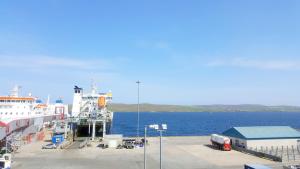 um navio de cruzeiro está ancorado na água em The Shetland Hotel em Lerwick