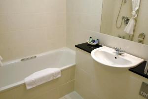 a bathroom with a sink and a bath tub and a sink at The Shetland Hotel in Lerwick