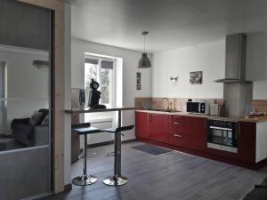 een keuken met rode kasten en een aanrecht bij l'escale in Montamisé