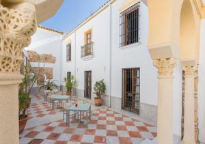 dziedziniec ze stołami i krzesłami w budynku w obiekcie Hotel Macià Alfaros w Kordobie