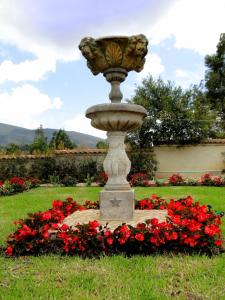 a fountain in the middle of a field of flowers at Villa de Los Angeles in Villa de Leyva