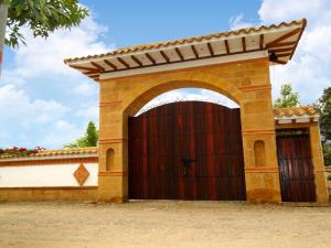 a brick garage with a large wooden door at Villa de Los Angeles in Villa de Leyva