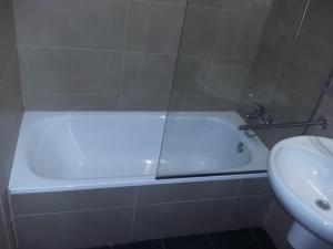 a white bath tub in a bathroom next to a sink at Hostal Rural San Andrés in Torres del Río