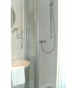 a bathroom with a shower and a sink at Hotel Meyn in Soltau