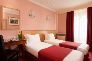 una camera d'albergo con due letti e una scrivania di Grand Hôtel Amelot a Parigi