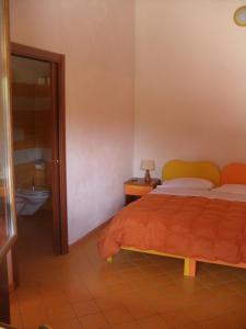 sypialnia z łóżkiem oraz łazienka z toaletą w obiekcie Agriturismo Usurtala w mieście Orani