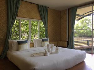 a bedroom with two beds with towels on them at รตะธารา รีสอร์ท ratathara resort in Ban Khlong Tamru