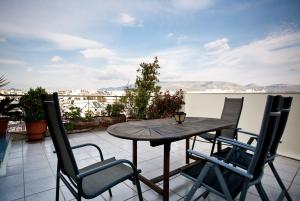 a table and chairs on a balcony with a view at Kalypso Apartment in Athens