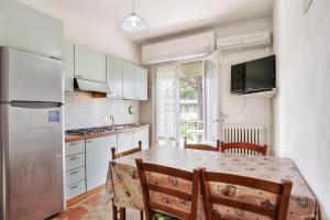a kitchen with a table and chairs and a refrigerator at Villaedi in Marina di Bibbona