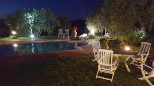 eine Gruppe Stühle, die nachts um einen Pool herum sitzen in der Unterkunft Tognazzi Casa Vacanze - Villa San Martino in Villa del Monte