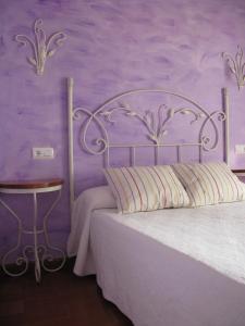 a bedroom with a bed with a purple wall at Casa Leny in La Vega