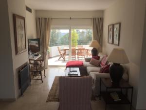 sala de estar con sofá, mesa y patio en Apartamento del Sol, en Estepona