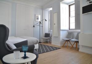 uma sala de estar com uma cama e uma mesa em Sophia Residences em Coimbra