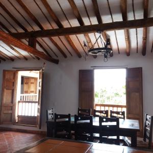 ein Esszimmer mit einem Tisch, Stühlen und einem Fenster in der Unterkunft El Zaguan in Barichara