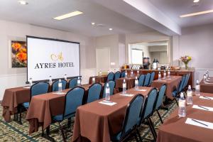 a conference room with tables and chairs and a screen at Ayres Suites Diamond Bar in Diamond Bar