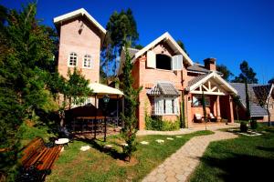 a brick house with a bench in front of it at Chalé Da Colina I in Monte Verde
