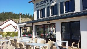 een groep tafels en stoelen buiten een restaurant bij Auberge du château de Joux in La Cluse et Mijoux