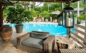 a wicker chair sitting next to a swimming pool at Villa Montaña Beach Resort in Isabela