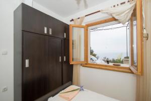 a bedroom with a window and a wooden cabinet at Stiniva-stone House in Vela Luka