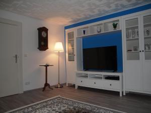 ein Wohnzimmer mit einem Flachbild-TV auf einem Entertainment-Center in der Unterkunft Döser Hus in Cuxhaven