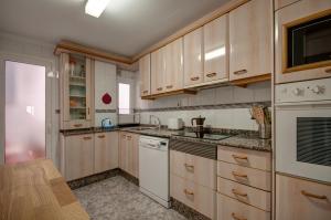 una cocina con electrodomésticos blancos y armarios de madera en Beds & Breaks Ferrero en Valencia