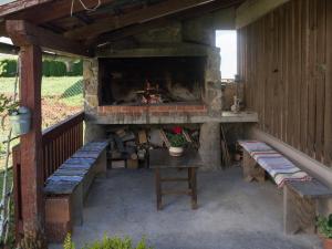 un patio al aire libre con chimenea de piedra y bancos en Breza Guesthouse, en Slunj