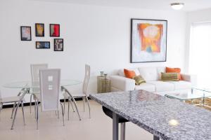 uma sala de estar com uma mesa e um sofá em Modern 3 Bedroom Apartment em San José
