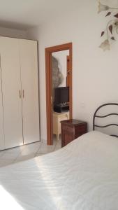 アグローポリにあるLa Terrazzaのベッドルーム(白いベッド1台、テレビ付)