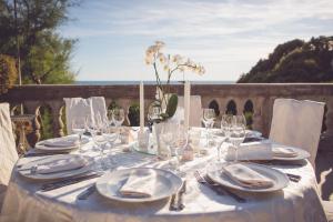a table with plates and glasses and a vase with flowers at Hotel Villa Margherita in Quercianella