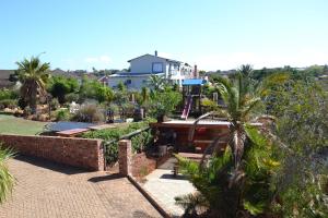 a house with a swimming pool and a garden at Dolphin View Guesthouse in Jeffreys Bay