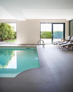 a house with a pool with chairs and windows at SUITE & POOL-Como House-160 mt-Private Indoor Swimming Pool, heated all year-Private Covered Parking-Private Garden and terrace-Fully equipped Kitchen in Como