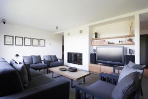 a living room with a couch and a tv at SUITE & POOL-Como House-160 mt-Private Indoor Swimming Pool, heated all year-Private Covered Parking-Private Garden and terrace-Fully equipped Kitchen in Como