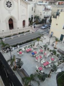 una vista sul tetto di un cortile con tavoli e ombrelloni di Appartamento di pregio In Piazza Durante Letojanni Taormina a Letoianni
