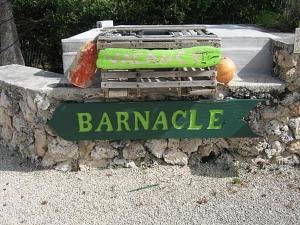 
a sign that is on the side of a stone wall at The Barnacle B&B in Big Pine Key
