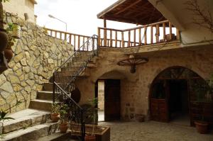 a stone building with a staircase and a door at Uchisar Cave House in Uçhisar