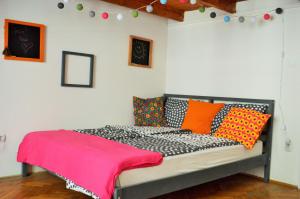 a bedroom with a bed with colorful pillows on it at Pulse Life Budapest Centre in Budapest