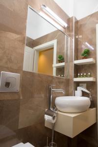 y baño con lavabo y espejo. en Vila Tako - Hotel, en Tirana