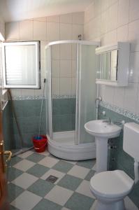 een badkamer met een douche, een toilet en een wastafel bij Guest House Djurovic in Sutomore