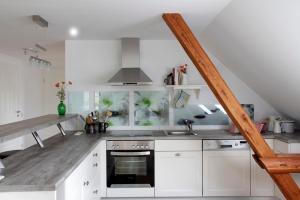a kitchen with white cabinets and a stove top oven at SchönErleben in Schwabstedt