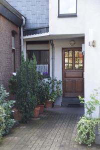 uma porta da frente de uma casa com vasos de plantas em Hotel Jägerhof em Ratingen