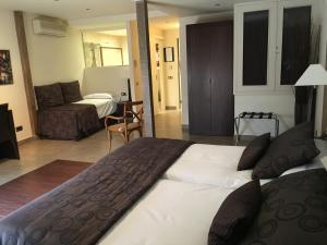 a hotel room with a large bed and a couch at Hotel Calabria in La Garriga