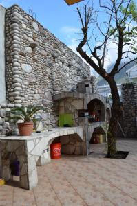 een stenen open haard voor een stenen muur bij Guest House Djurovic in Sutomore