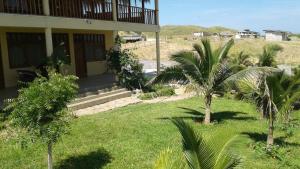 a house with palm trees in front of a yard at Villa Sunset Beach Peru in Los Órganos