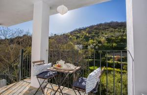 patio con mesa y sillas en el balcón en Casa Valle del Genal, en Igualeja